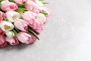 Photo of Beautiful bouquet of tulips on light table. Space for text