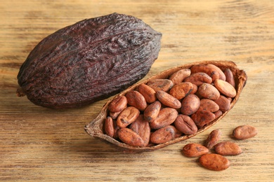 Photo of Cocoa pod and beans on wooden table