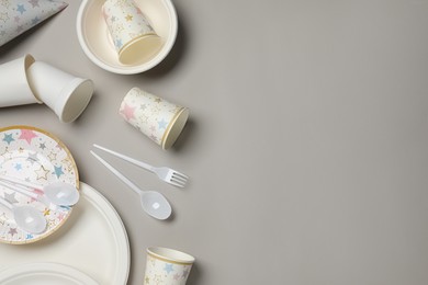 Photo of Disposable tableware on light grey background, flat lay. Space for text