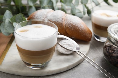 Delicious latte macchiato and croissant on table. Space for text