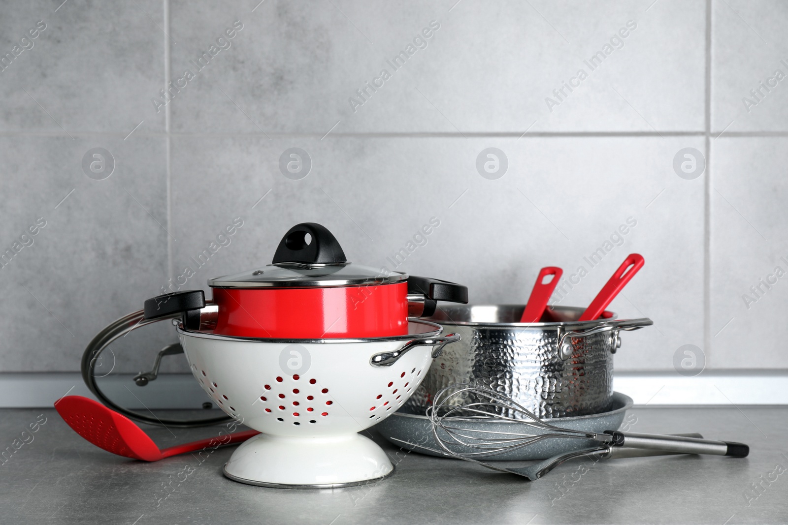 Photo of Set of different cooking utensils on grey countertop in kitchen