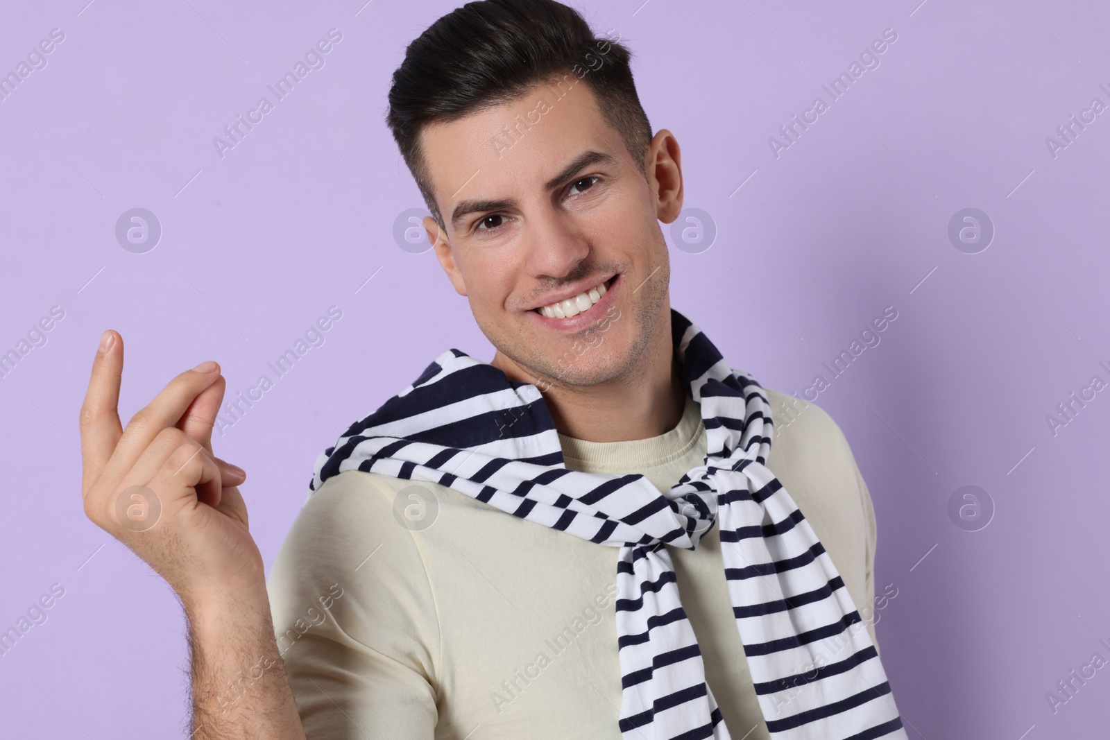 Photo of Handsome man snapping fingers on violet background