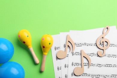 Photo of Tools for creating baby songs. Flat lay composition with maracas on green background