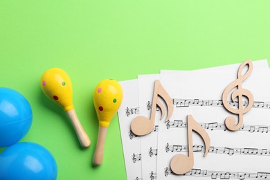 Tools for creating baby songs. Flat lay composition with maracas on green background