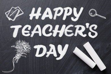 Image of Text Happy Teacher's Day with drawings and chalk on blackboard, top view. Greeting card design