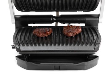 Photo of Electric grill with tasty meat steaks isolated on white