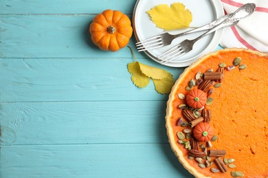 Photo of Delicious homemade pumpkin pie on light blue wooden table, flat lay. Space for text