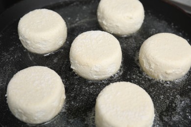 Photo of Uncooked cottage cheese pancakes in frying pan, closeup