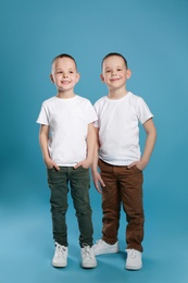 Photo of Full length portrait of cute twin brothers on color background
