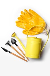 Photo of Watering can, gardening tools and gloves on white background, flat lay