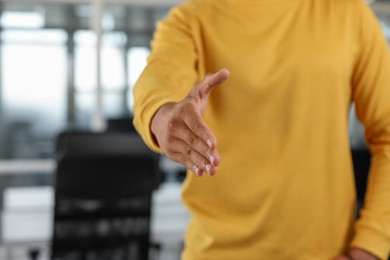 Photo of Man welcoming and offering handshake in office, closeup. Space for text