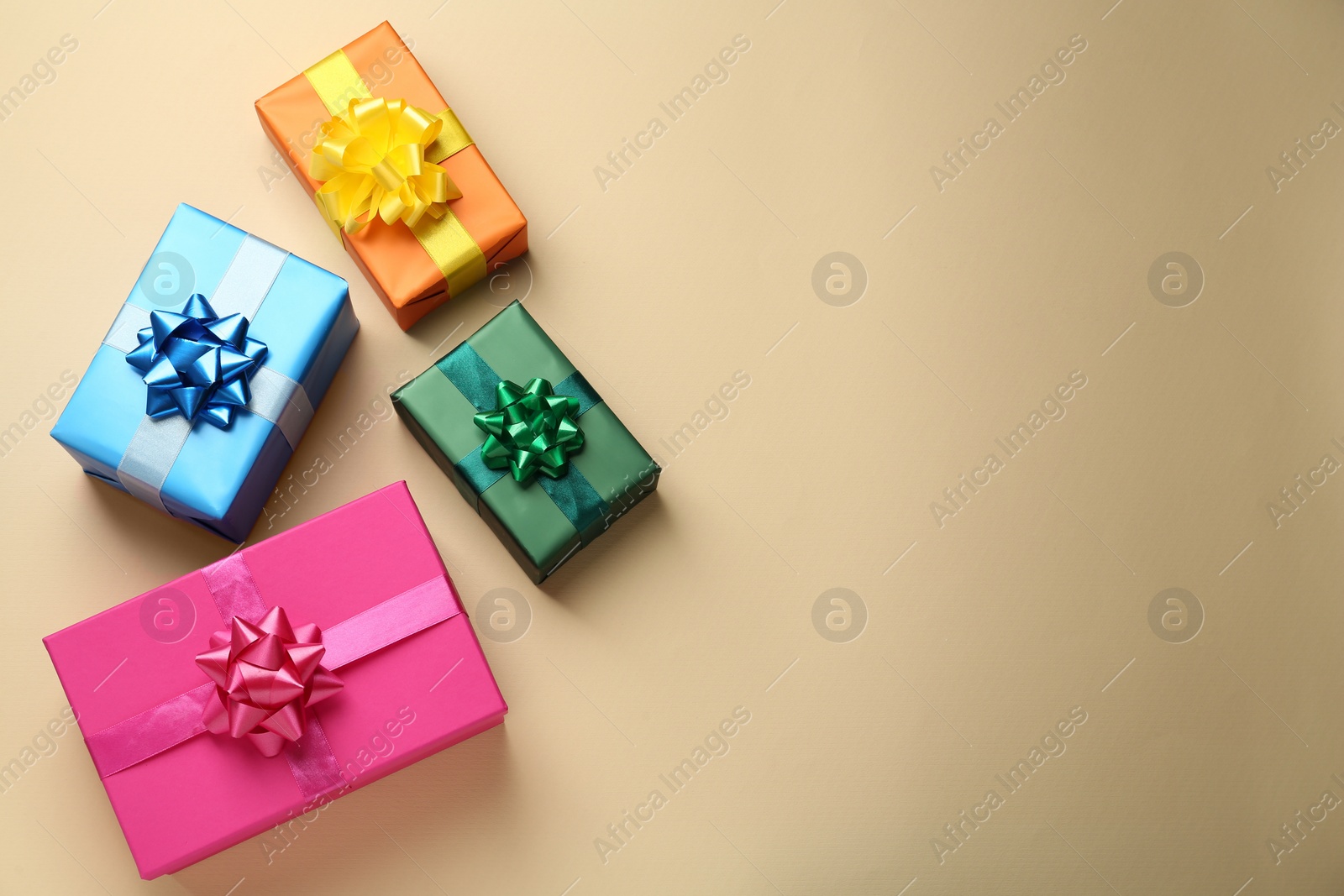 Photo of Many colorful gift boxes on beige background, flat lay. Space for text