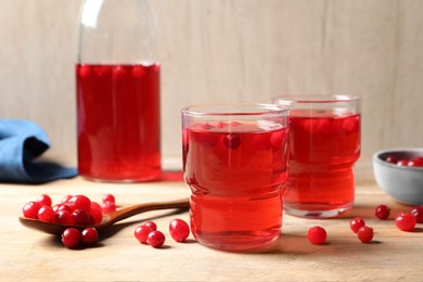 Tasty cranberry juice in glasses and fresh berries on wooden table, closeup