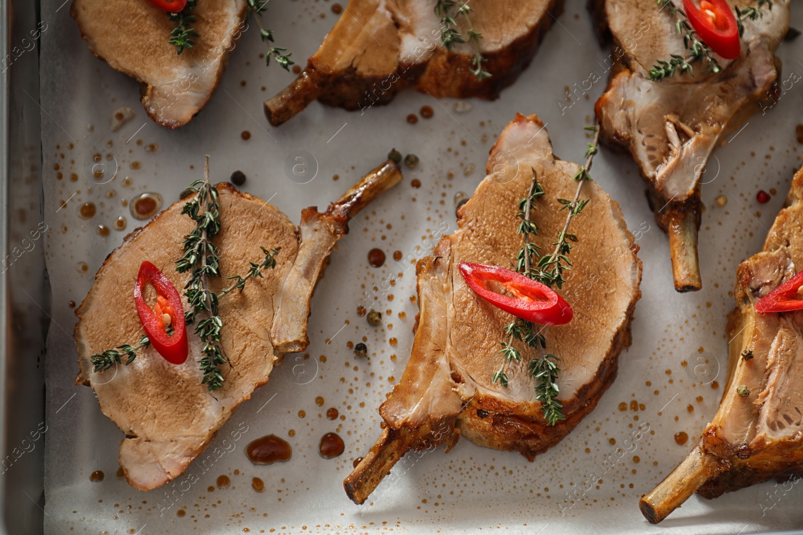 Photo of Delicious roasted ribs in baking tray, flat lay