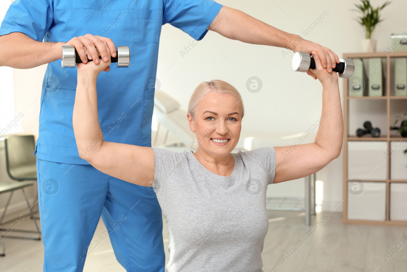 Photo of Physiotherapist working with patient in clinic. Rehabilitation therapy