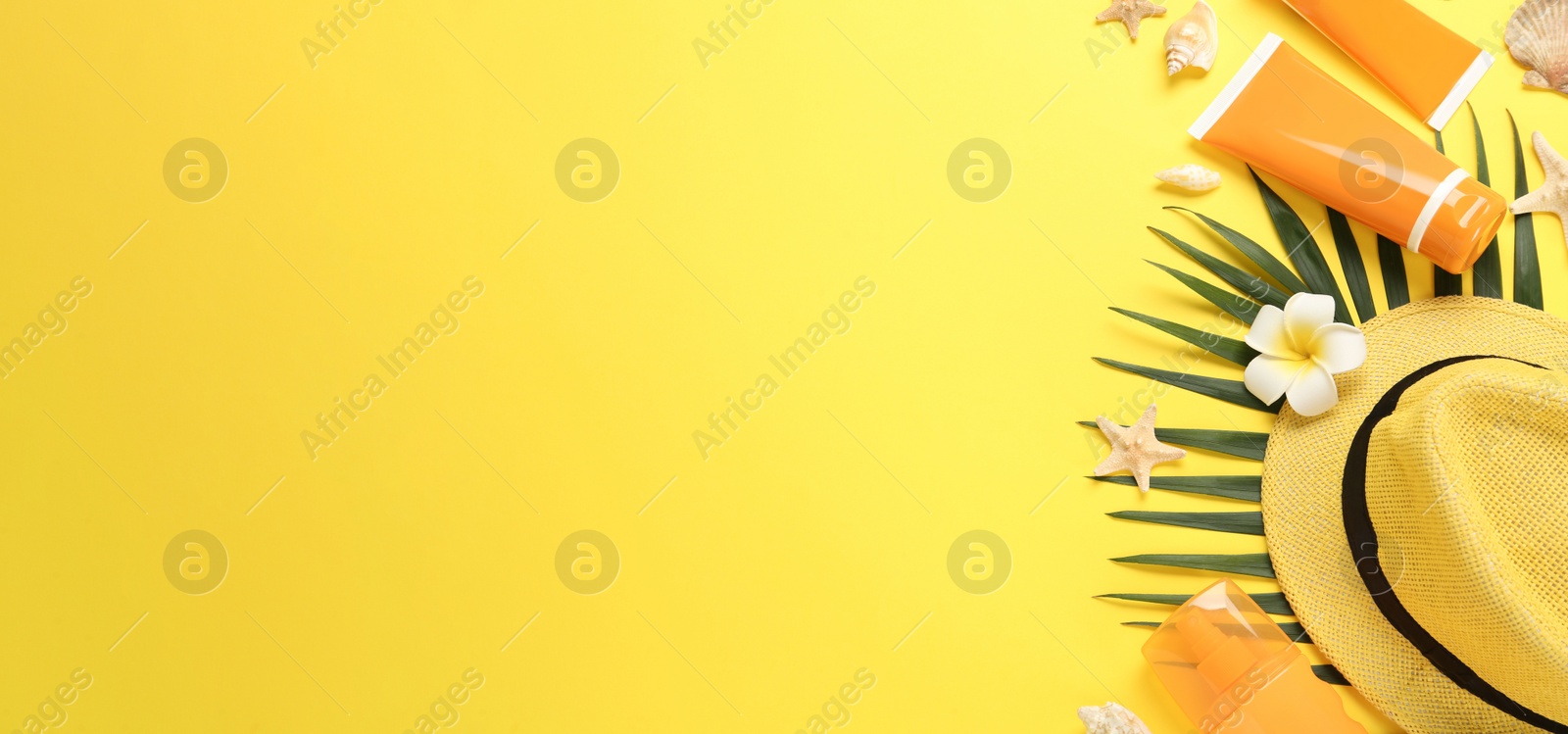 Photo of Sun protection products and beach accessories on yellow background, flat lay. Space for text