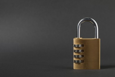 Photo of One steel combination padlock on dark grey background, closeup. Space for text