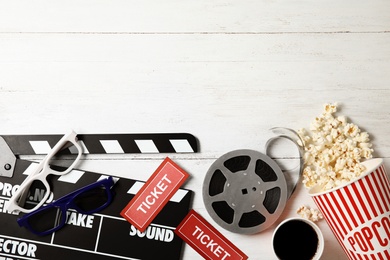 Photo of Flat lay composition with clapper, popcorn and space for text on wooden background. Cinema snack