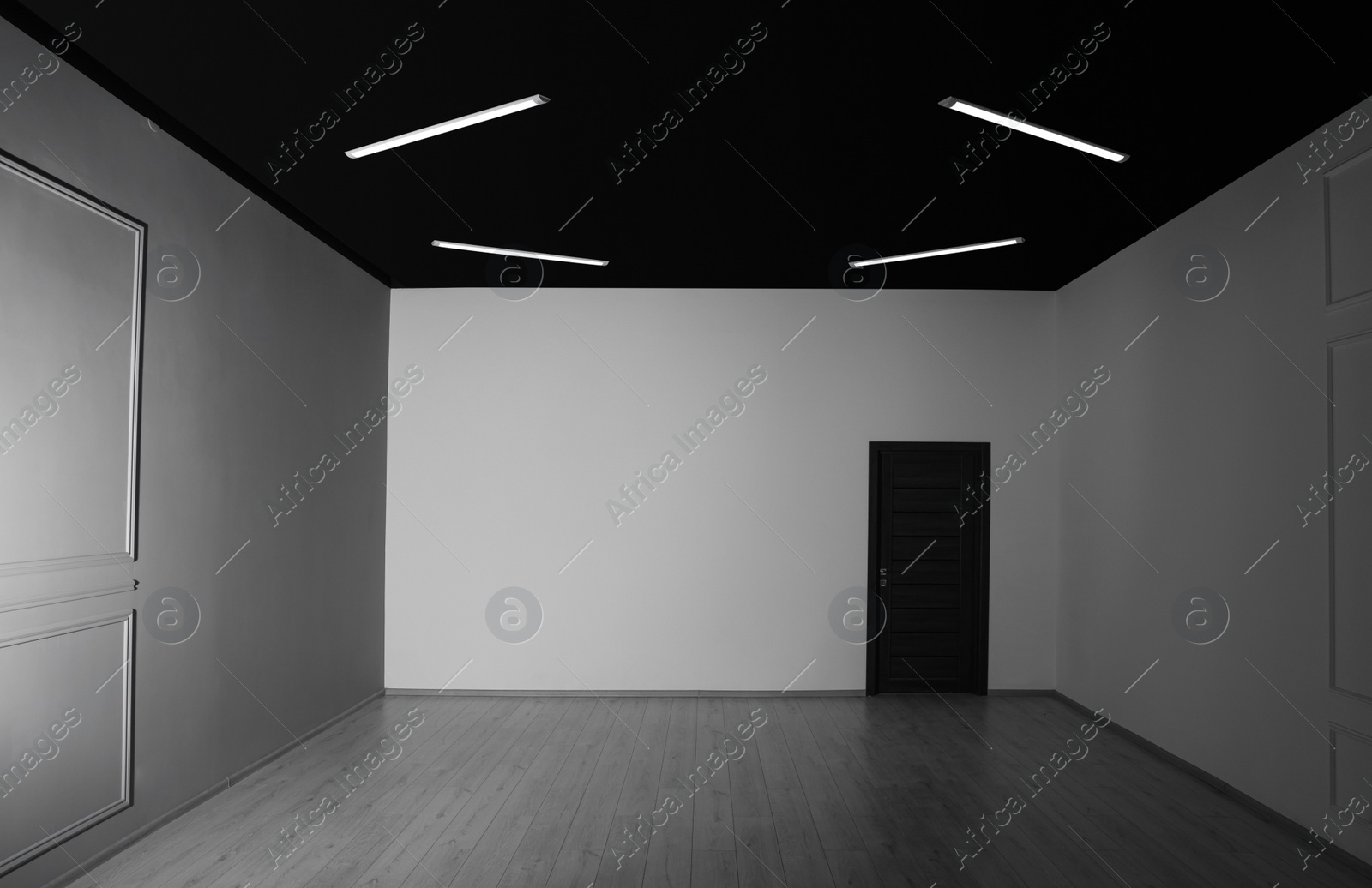 Photo of Empty renovated room with white walls and black door