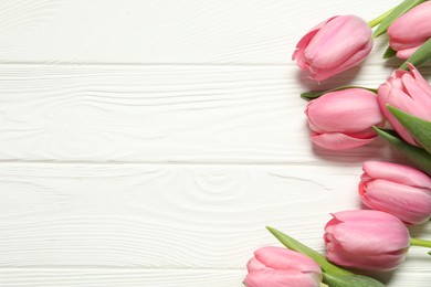 Happy Mother's Day. Beautiful pink tulips on white wooden table, flat lay. Space for text