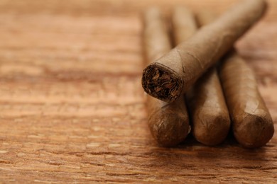 Many cigars on wooden table, closeup. Space for text