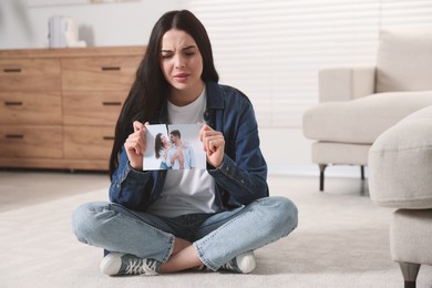 Photo of Upset woman ripping photo at home. Divorce concept
