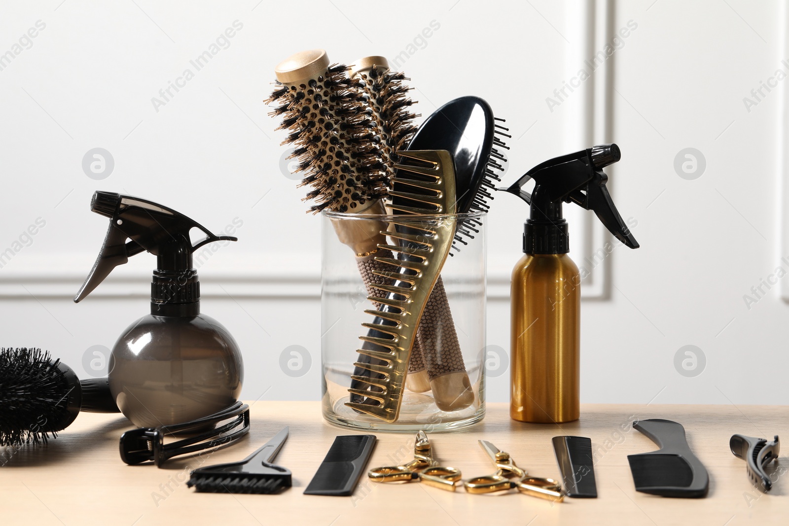 Photo of Hairdresser tools. Different scissors and combs on wooden table in salon