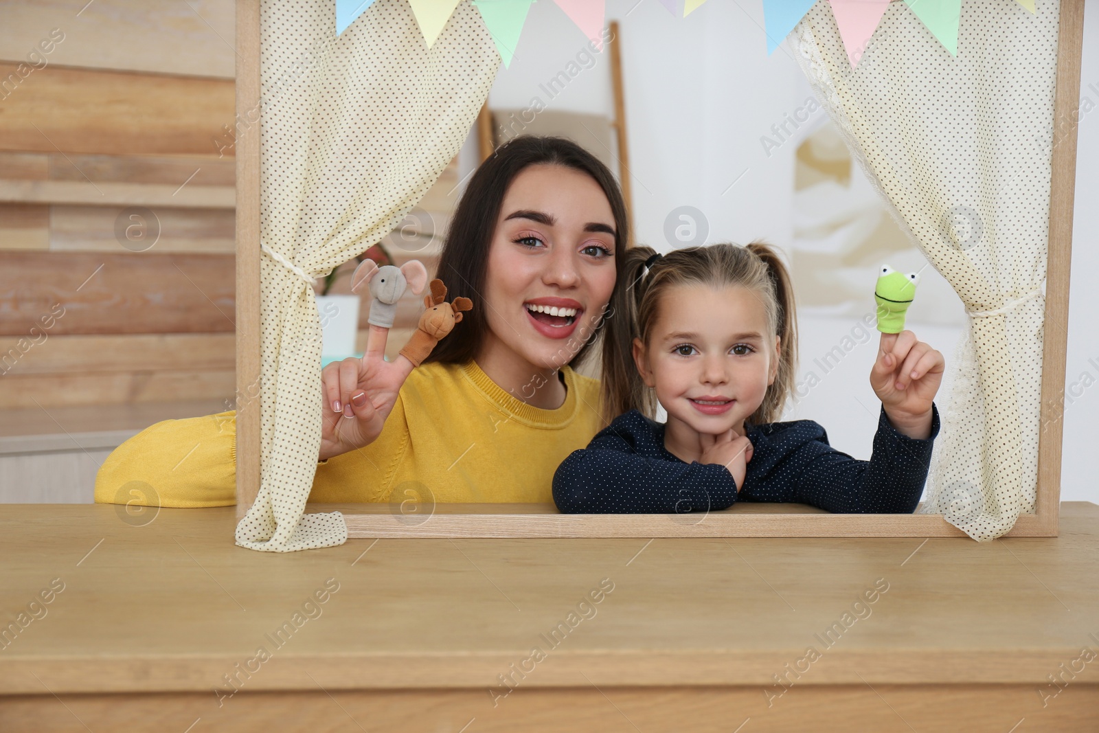 Photo of Mother and daughter performing puppet show at home