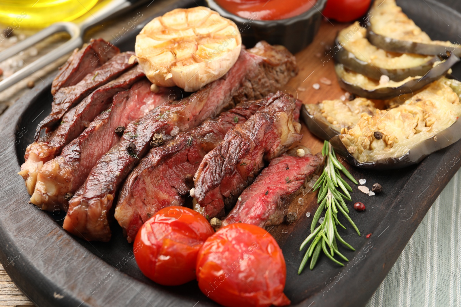 Photo of Delicious grilled beef steak with vegetables and spices on table, closeup