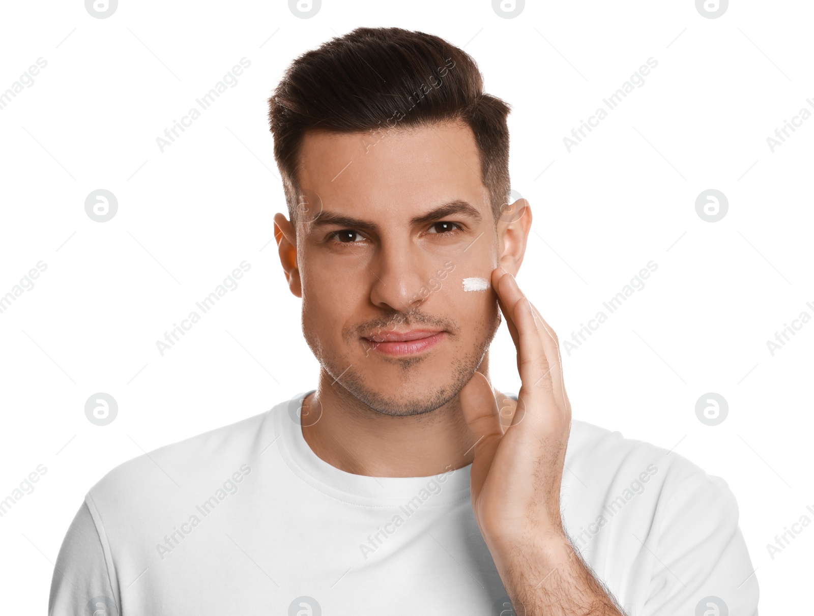 Photo of Handsome man applying face cream on white background