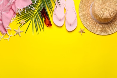 Flat lay composition with different beach objects on yellow background, space for text