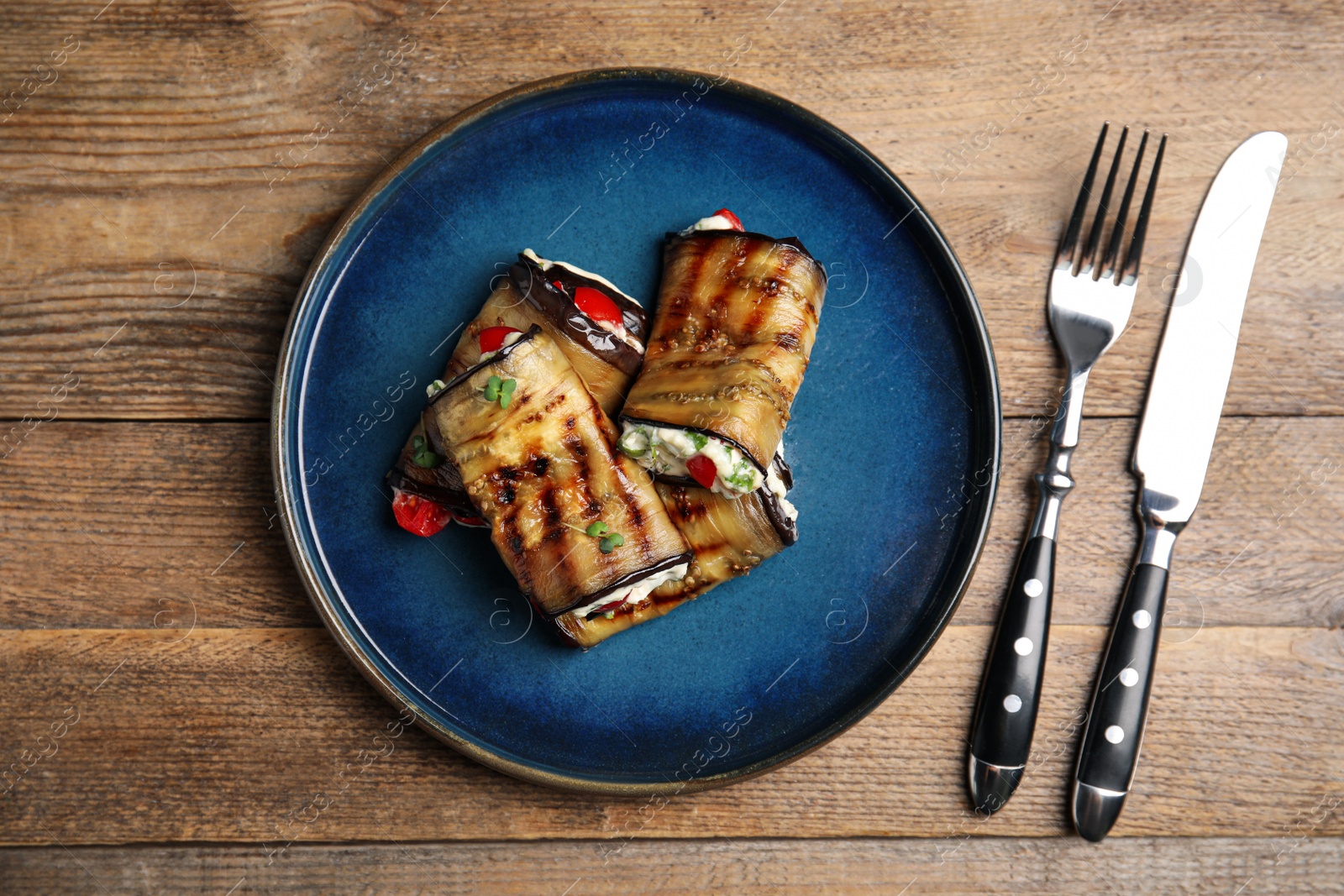 Photo of Delicious baked eggplant rolls served on wooden table, flat lay