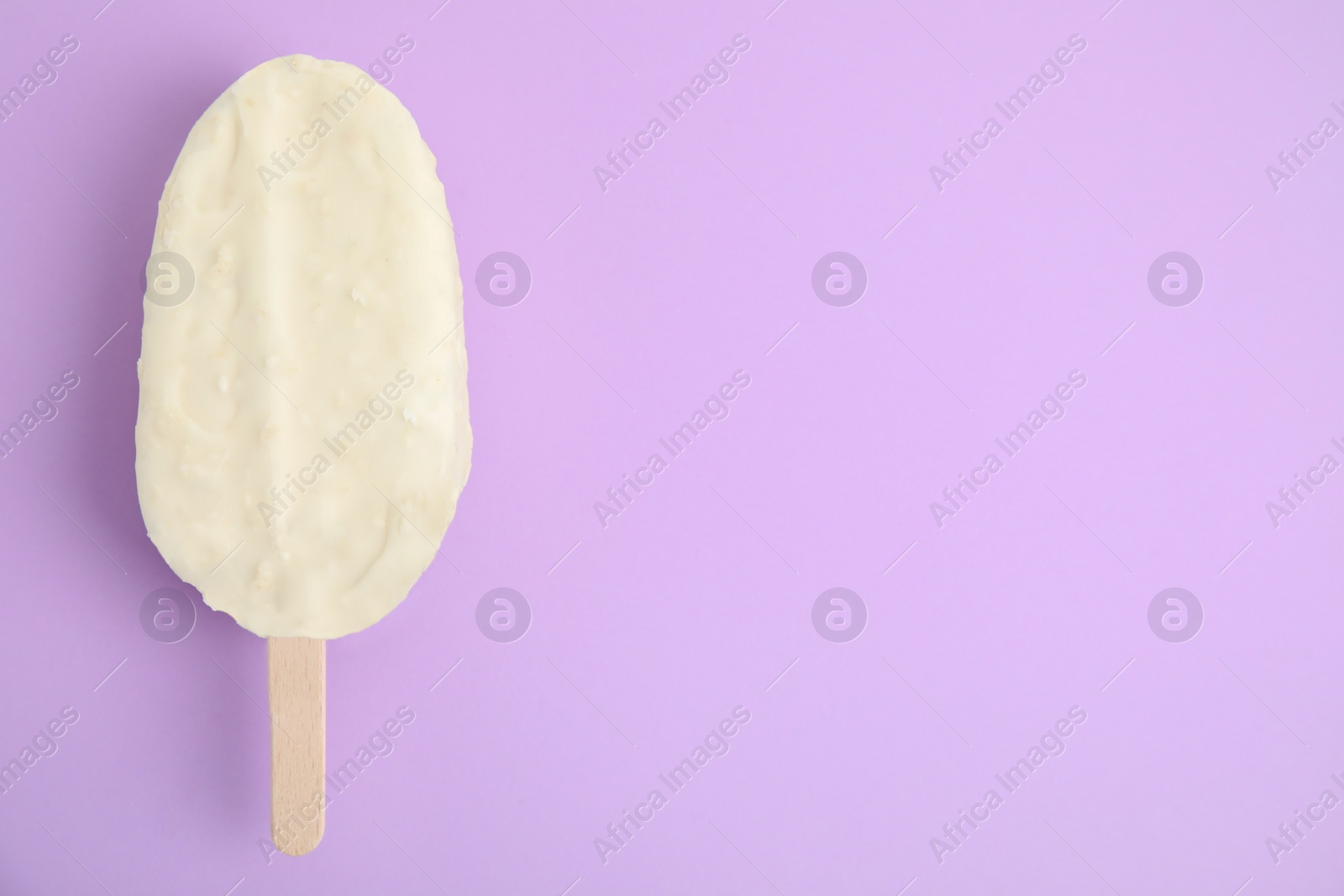 Photo of Ice cream with glaze on lilac background, top view. Space for text