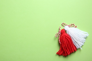 Traditional martisor on green background, top view with space for text. Beginning of spring celebration