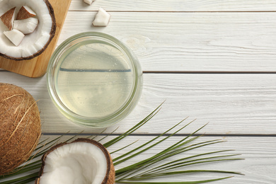 Photo of Flat lay composition with coconut oil on white wooden table, space for text