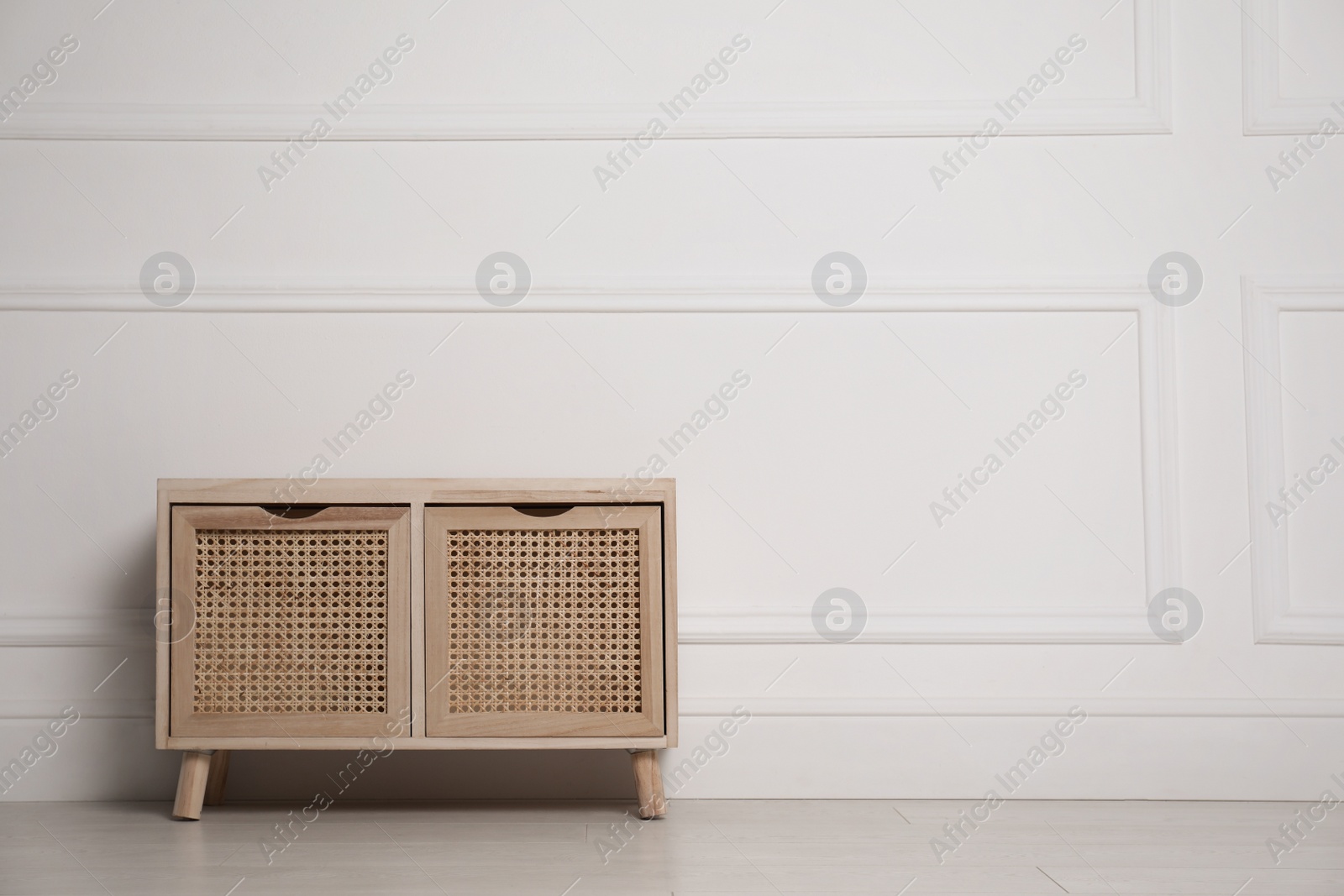 Photo of Wooden chest of drawers near white wall indoors, space for text