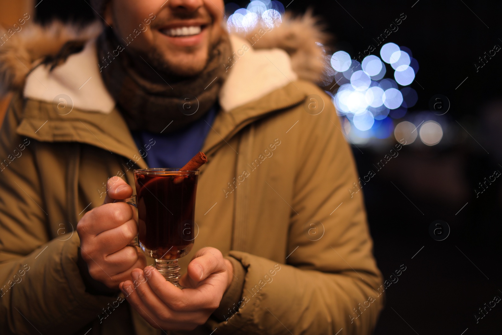 Photo of Man with tasty mulled wine at winter fair, closeup
