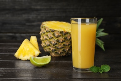 Glass with delicious pineapple juice on table