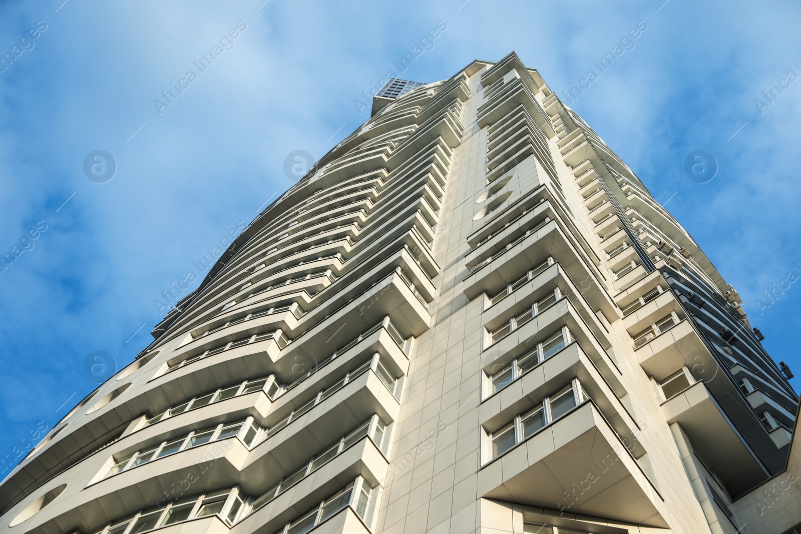 Photo of KYIV, UKRAINE - MAY 23, 2019: Modern dwelling building against sky with clouds