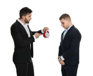 Businessman with alarm clock scolding employee for being late on white background