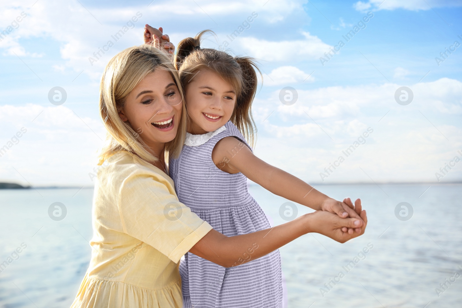 Photo of Happy mother and her child on beach. Spending time in nature