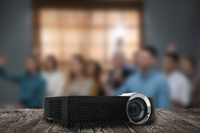 Image of Modern video projector and blurred people on background