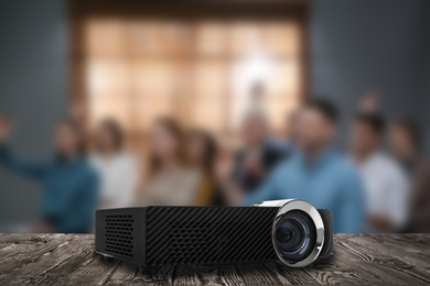 Modern video projector and blurred people on background