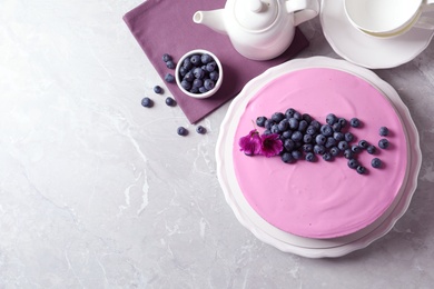 Photo of Flat lay composition with tasty blueberry cake on light grey table. Space for text