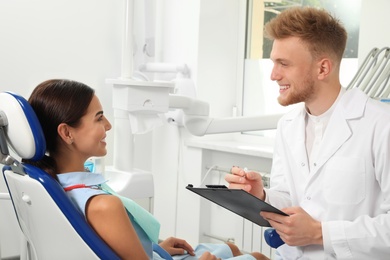 Photo of Professional dentist working with patient in clinic