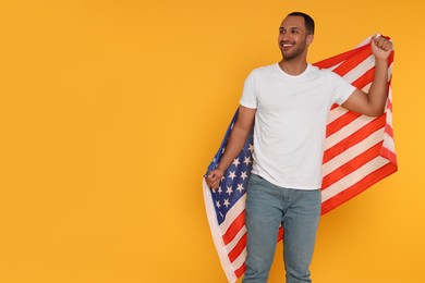 Photo of 4th of July - Independence Day of USA. Happy man with American flag on yellow background, space for text