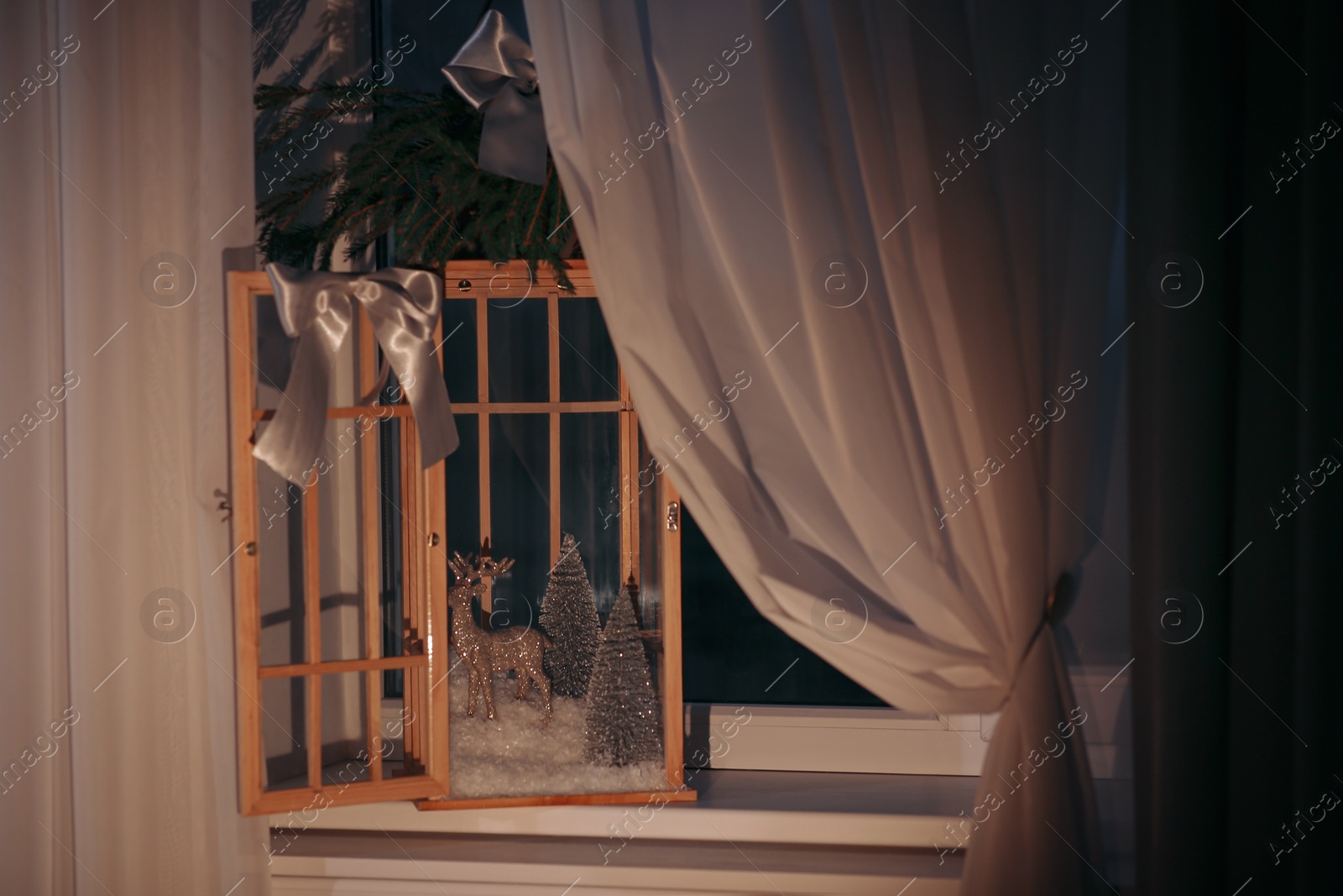 Photo of Vintage wooden lantern with beautiful Christmas composition on window sill indoors