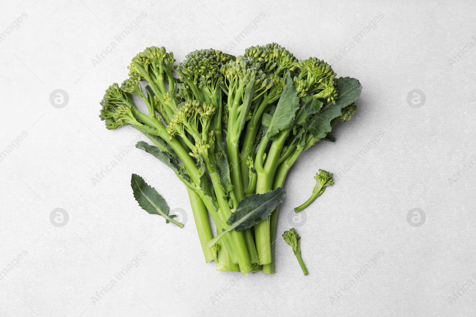 Photo of Fresh raw broccolini on white background, flat lay. Healthy food