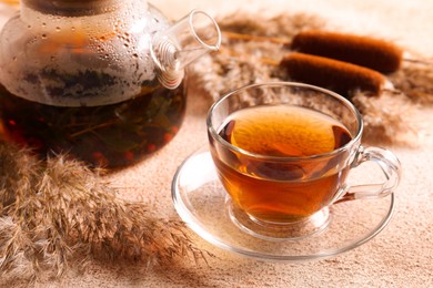 Photo of Hot tea and beautiful dry reed on beige textured table