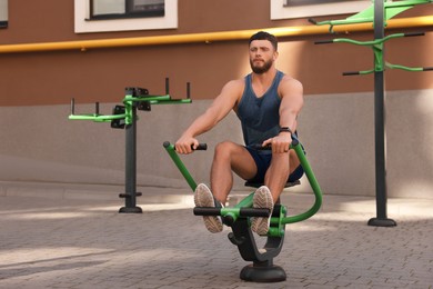 Man training on rowing machine at outdoor gym